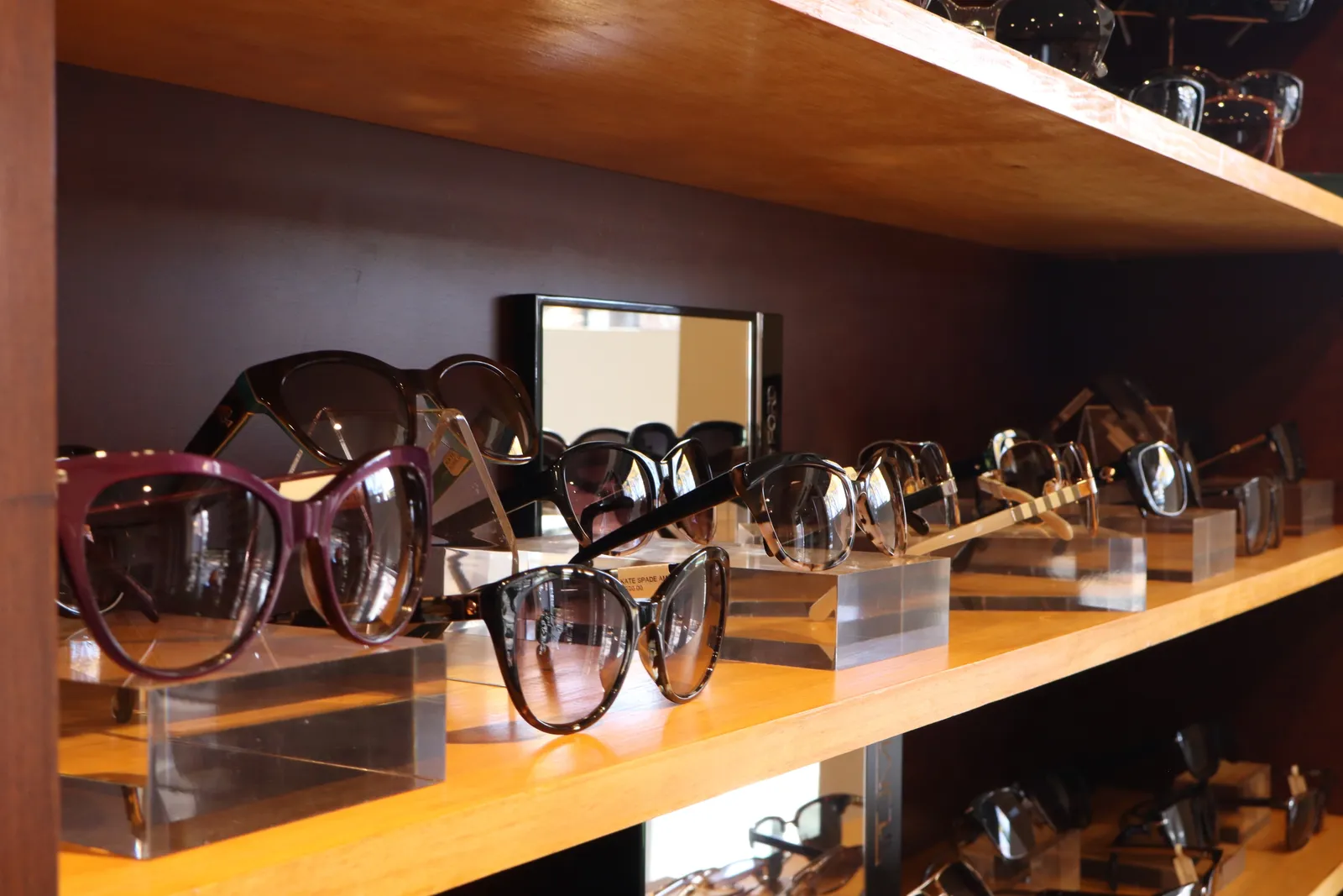A shelf of designer eyeglasses and sunglasses on display at West & Stannish
